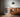 A dimly lit living room in the evening with a soft warm glow along the wall